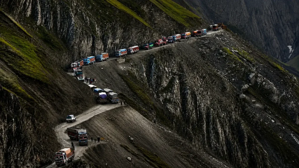 Mountain road connecting Ladakh routes with vehicles navigating steep cliffs